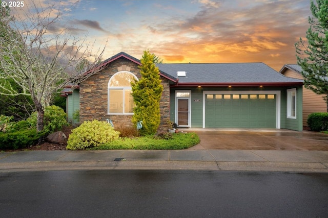 ranch-style house featuring stone siding, an attached garage, and driveway