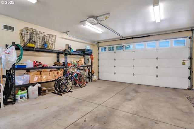 garage featuring a garage door opener and visible vents