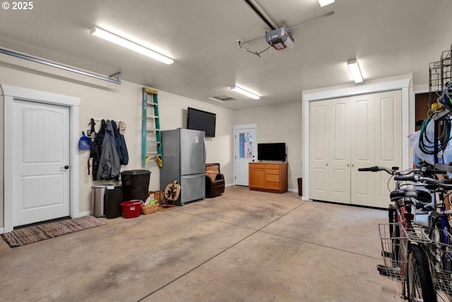 garage featuring a garage door opener and freestanding refrigerator