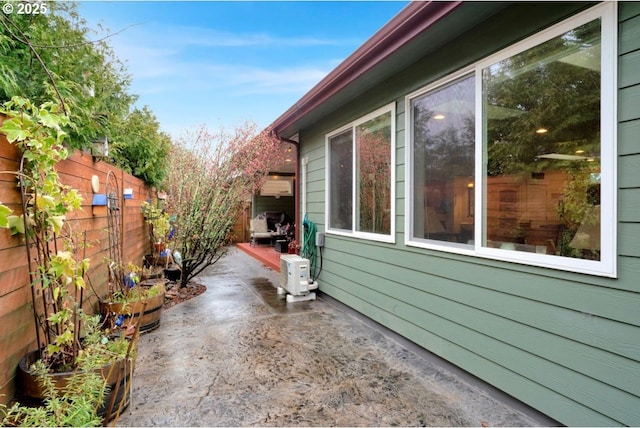 view of property exterior featuring a patio area, ac unit, and fence