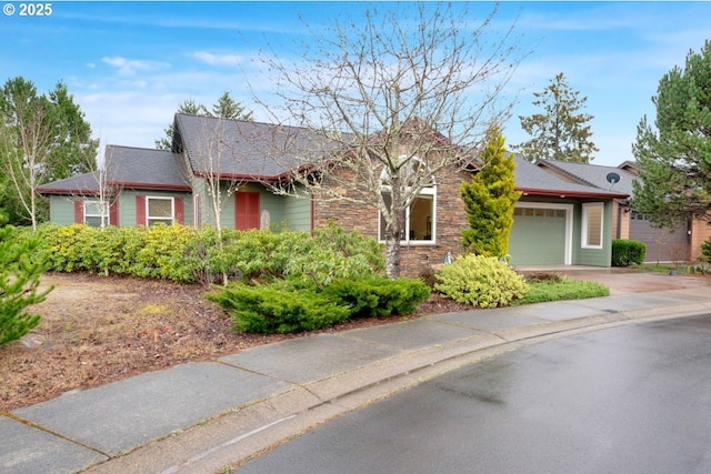 single story home with an attached garage, stone siding, and driveway