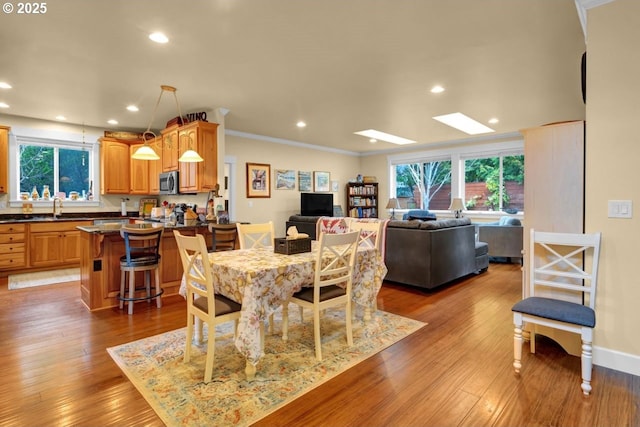 dining space featuring a wealth of natural light, light wood-style floors, recessed lighting, and crown molding