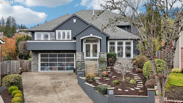 craftsman inspired home with stucco siding, stone siding, fence, french doors, and driveway