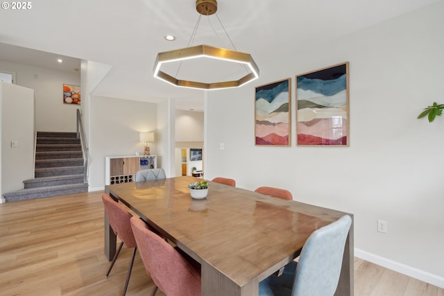 dining area featuring baseboards, recessed lighting, wood finished floors, and stairs