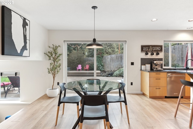 dining area featuring light wood-type flooring and a healthy amount of sunlight
