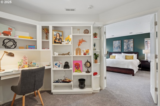 carpeted bedroom featuring built in desk