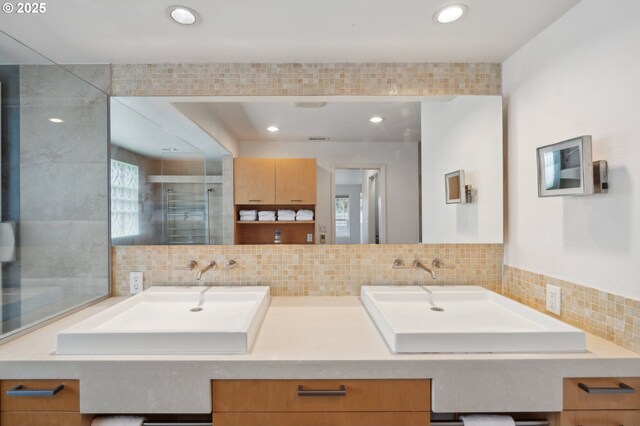 bathroom with tasteful backsplash, vanity, tile patterned floors, and tiled bath