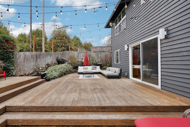 wooden terrace featuring an outdoor hangout area and a fenced backyard