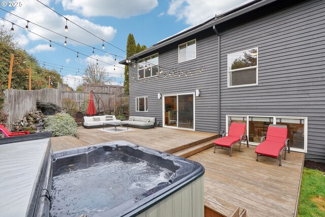 rear view of property with central AC, an outdoor living space, a deck, and a trampoline