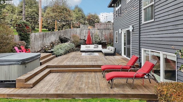 deck featuring an outdoor living space, a fenced backyard, and a hot tub