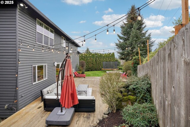 rear view of house featuring a wooden deck and solar panels