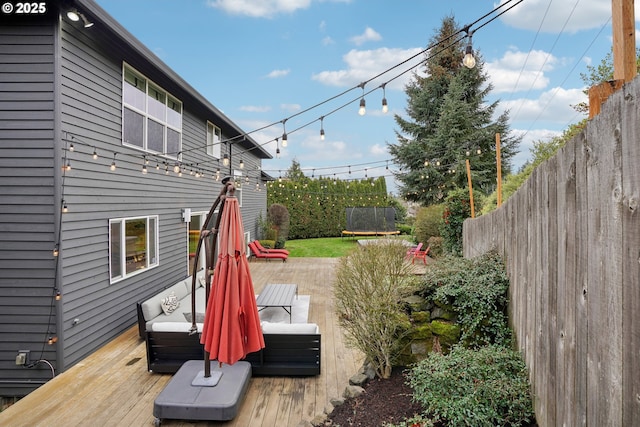 view of yard with fence, a wooden deck, and a hot tub