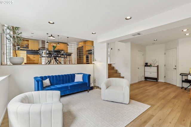 living area with visible vents, baseboards, recessed lighting, stairway, and hardwood / wood-style floors
