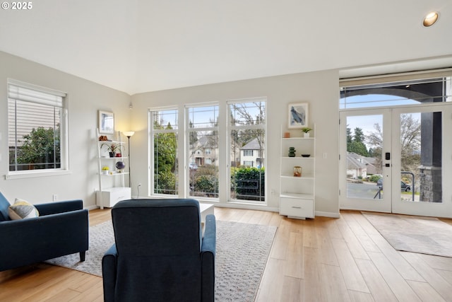 living area with light wood-style flooring and french doors