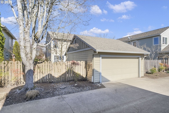 view of side of property with a detached garage, roof with shingles, fence, an outdoor structure, and board and batten siding