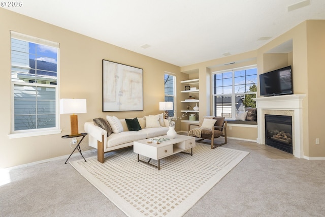 living area with carpet floors, a fireplace with flush hearth, and baseboards