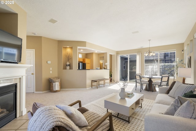 living area with a high end fireplace, light carpet, a textured ceiling, and baseboards