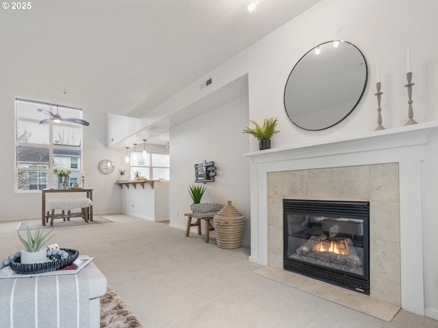 carpeted living room featuring visible vents and a tile fireplace