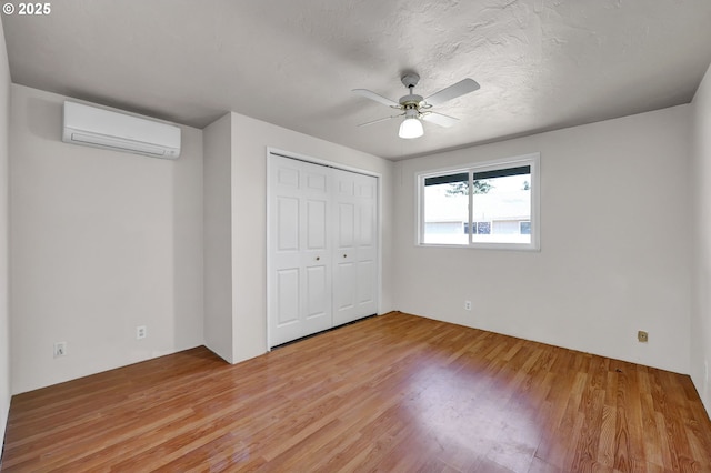 5430 E St, Springfield, OR 97478 - unfurnished bedroom with a wall mounted AC, light wood finished floors, a closet, and ceiling fan