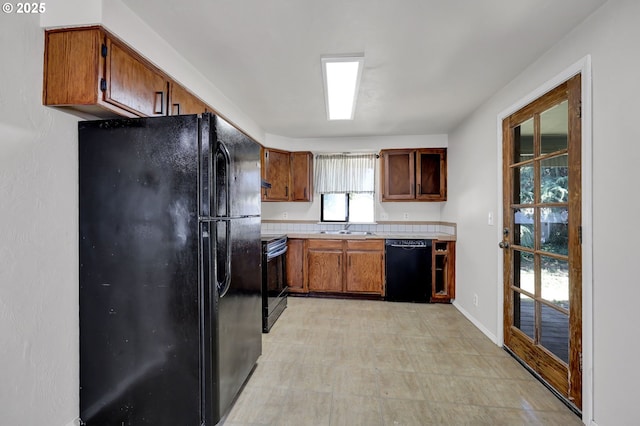 5430 E St, Springfield, OR 97478 - kitchen featuring black appliances, light countertops, brown cabinetry, and light floors