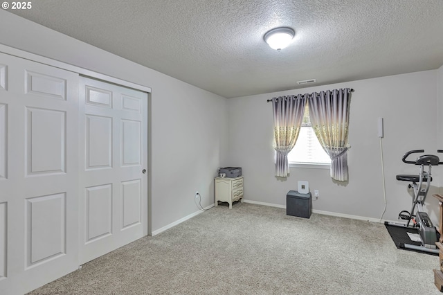 3963 NW 148th Pl, Portland, OR 97229 - exercise room with a textured ceiling, carpet flooring, and baseboards