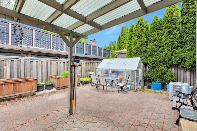 3963 NW 148th Pl, Portland, OR 97229 - fenced backyard featuring a patio area, a greenhouse, central air condition unit, and outdoor dining area