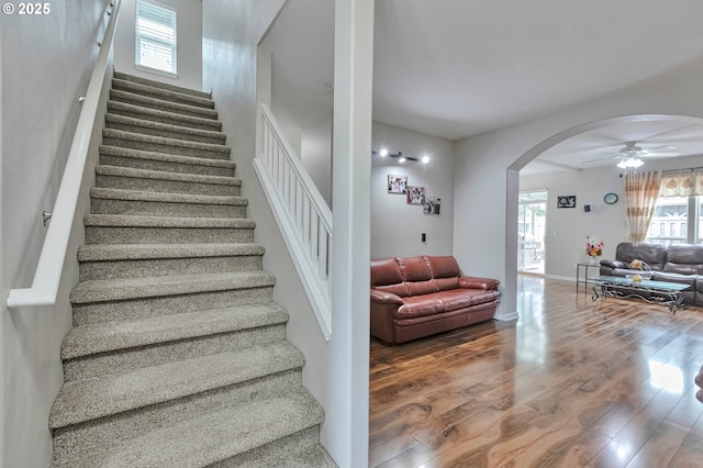 3963 NW 148th Pl, Portland, OR 97229 - staircase featuring arched walkways, ceiling fan, wood finished floors, and baseboards