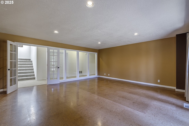 spare room featuring baseboards, stairs, a textured ceiling, french doors, and recessed lighting