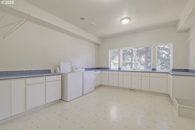 laundry room with light floors, washing machine and dryer, visible vents, and cabinet space