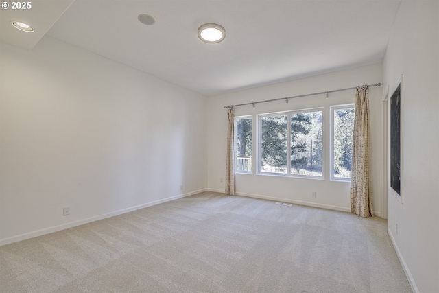 unfurnished room with recessed lighting, baseboards, visible vents, and light colored carpet