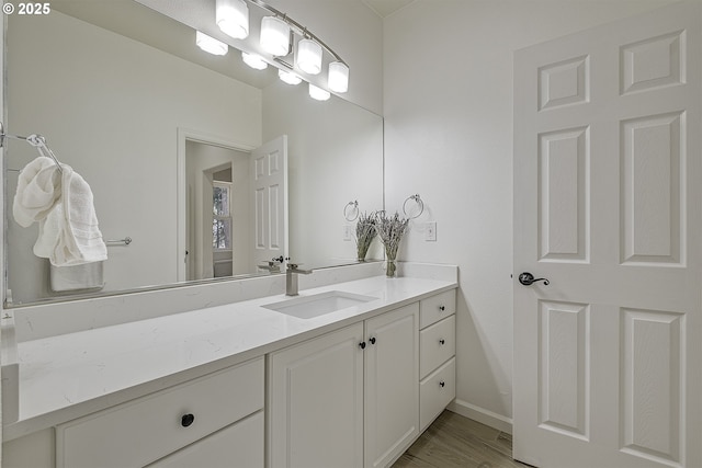 bathroom featuring wood finished floors, vanity, and baseboards