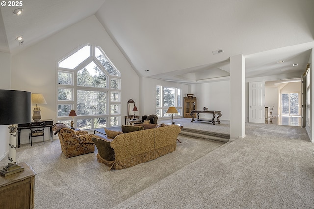 living room featuring high vaulted ceiling, carpet, and visible vents