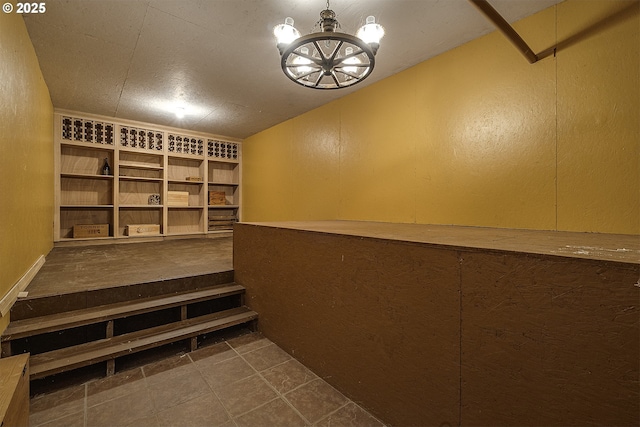 wine room with tile patterned flooring and a notable chandelier