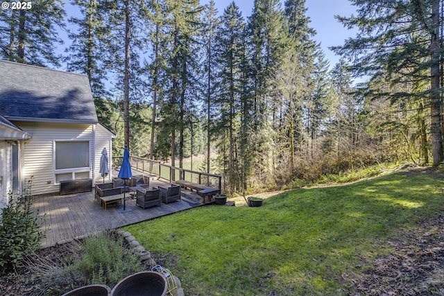 view of yard with a deck, a view of trees, and an outdoor living space