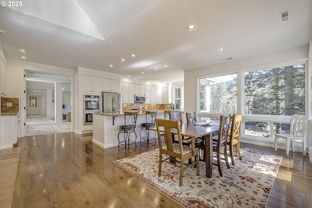 dining space featuring visible vents, wood finished floors, and recessed lighting