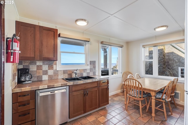 kitchen featuring tasteful backsplash, sink, stainless steel dishwasher, and tile counters