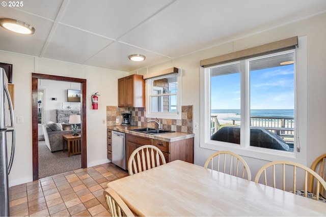 kitchen with tasteful backsplash, a water view, sink, and appliances with stainless steel finishes