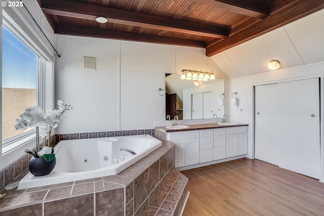 bathroom with vaulted ceiling with beams, wood ceiling, vanity, tiled tub, and hardwood / wood-style floors