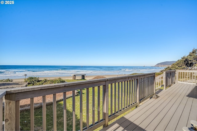 deck with a view of the beach, a yard, and a water view