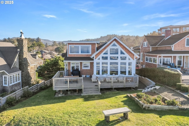 back of house featuring a deck and a lawn