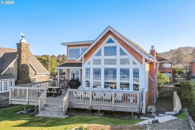 rear view of property featuring a yard and a deck