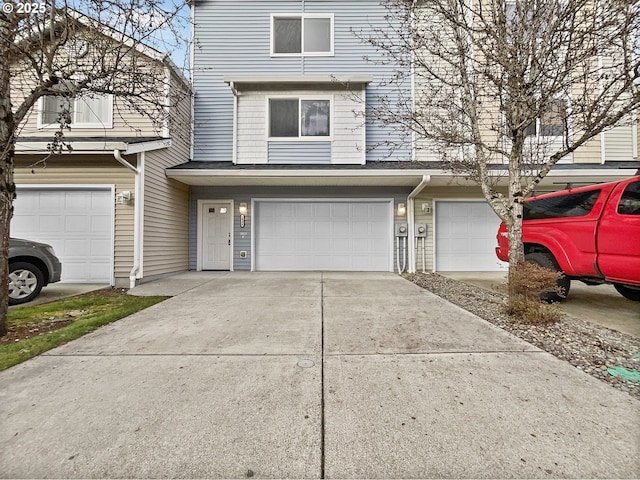 view of property featuring a garage and concrete driveway