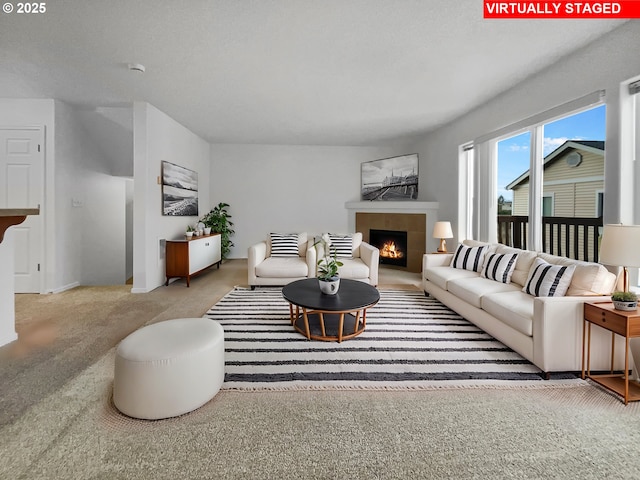 carpeted living area with a tile fireplace