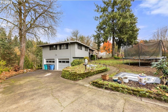 835 E 4th St, La Center, WA 98629 - view of side of property featuring a garage, a trampoline, and driveway