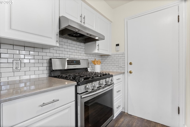 kitchen with gas stove, light countertops, under cabinet range hood, and decorative backsplash