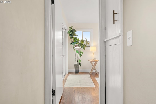 corridor with wood finished floors and baseboards