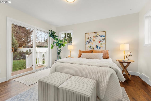 bedroom featuring access to outside, visible vents, baseboards, and wood finished floors