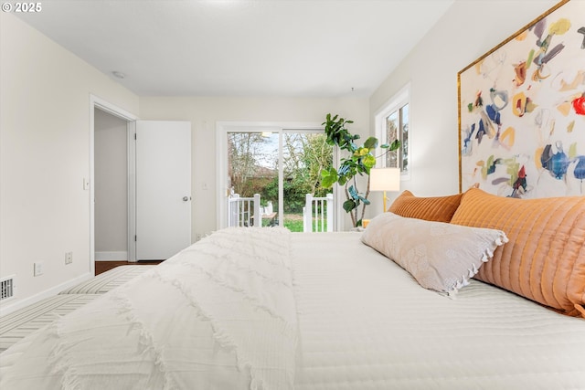 bedroom with access to exterior, visible vents, and baseboards