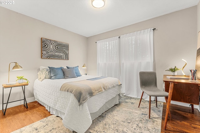 bedroom with baseboards and wood finished floors