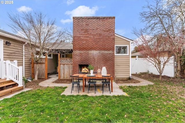 exterior space with a brick fireplace, fence, and a patio